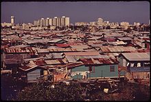 MODERN_BUILDINGS_TOWER_OVER_THE_SHANTIES_CROWDED_ALONG_THE_MARTIN_PENA_CANAL_-_NARA_-_546369